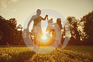 Family playing with a child at sunset on the nature