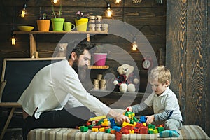 Family playing with constructor at home. Dad and child play with toy cars, bricks. Father and happy son play with