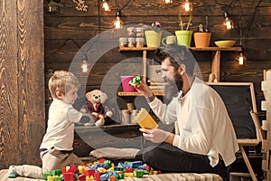 Family playing with constructor at home. Dad and child play with toy cars, bricks. Nursery with toys and chalkboard on