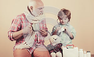 Family playing in doctor and patient. Handsome old man grandfather is having pain and his grandson supports him.