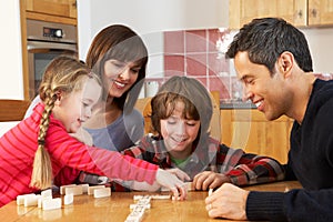 Family Playing Dominoes In Kitchen