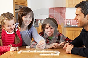 Family Playing Dominoes In Kitchen