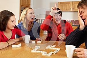 Family Playing Dominoes In Kitchen