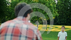 Family playing frisbee in field. Parents and children throwing frisbee disc