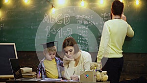 Family playing at home. Parents helping children with their homework at home. Young father and mother helping sons study