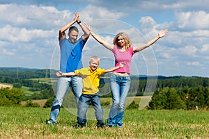 Family playing on meadow in summer