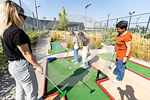 family playing mini golf on a cruise liner. Child having fun with active leisure on vacations.