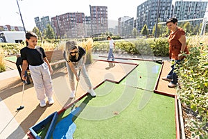 family playing mini golf on a cruise liner. Child having fun with active leisure on vacations.