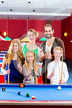 Family playing pool billiard game