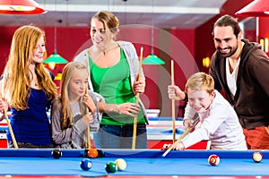 Family playing pool billiard game