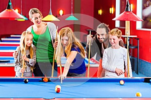 Family playing pool billiard game