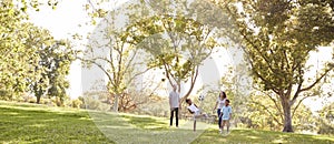 Family Playing Soccer In Park Together