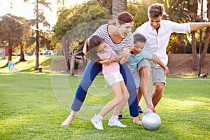 Family Playing Soccer In Park Together