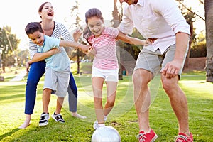 Family Playing Soccer In Park Together