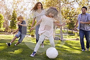 Family Playing Soccer In Park Together