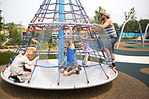 Family Playing on Spinning Playground Equipment at Park