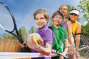 Family playing tennis holding rackets and ball