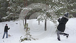 Family playing by throwing snowballs in the winter