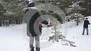 Family playing by throwing snowballs in the winter