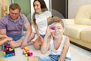 Family playing with toy blocks at home on the floor