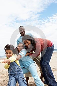 Family playing tug of war on beach