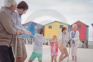 Family playing tug of war at beach