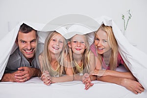 Family playing under the quilt