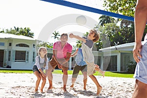 Family Playing Volleyball In Garden At Home