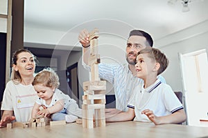 A family plays board games sitting at a table indoors.