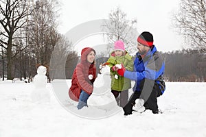 Family plays in park in winter photo