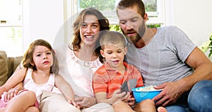 Family with pop-corn on a couch