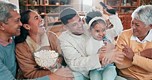 Family, popcorn and watching a movie on a sofa at home to relax, bond and quality time. Happy men, women or parents and