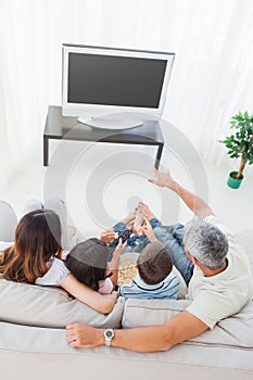 Family with popcorn watching their television on sofa