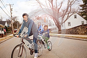 Family portrait on bicycles, son towed in tandem