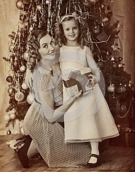 Family portrait of child with mother near Christmas tree.