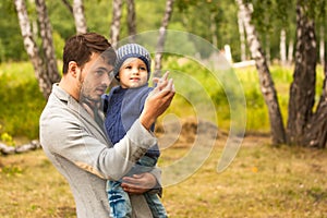 Family portrait. Father play with his child. Father holding a child in his arms. They are happy. Happy family walking outdoor