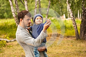 Family portrait. Father play with his child. Father holding a child in his arms. They are happy. Happy family walking outdoor