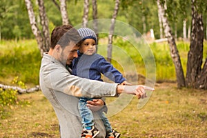 Family portrait. Father play with his child. Father holding a child in his arms. They are happy. Happy family walking outdoor