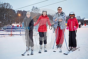 Family portrait of four skiers standing at ski