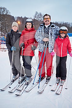 Family portrait of four skiers standing at ski