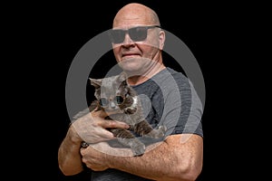 family portrait of middle aged man who holds his grey cat in hands on black background