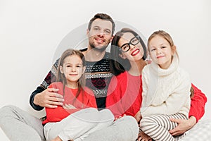 Family portrait: mother, father and two sisters look directly in