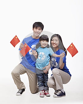 Family Portrait, one child with parents, waving Chinese flags, studio shot