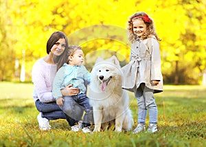 Family portrait, pretty young mother and children walks with dog