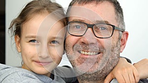 Family portrait of senior father and little blond daughters are hugging indoors and smiling, fathers day celebration