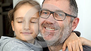 Family portrait of senior father and little blond daughters are hugging indoors and smiling, fathers day celebration