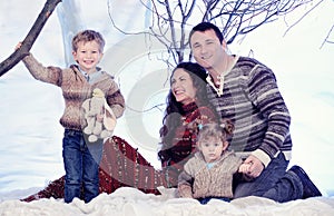 Family portrait sits on studio snow forest background