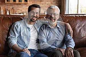 Family portrait smiling mature father and grownup son hugging