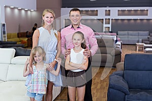 Family posing near new sofa