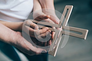 Family prayer with wooden cross